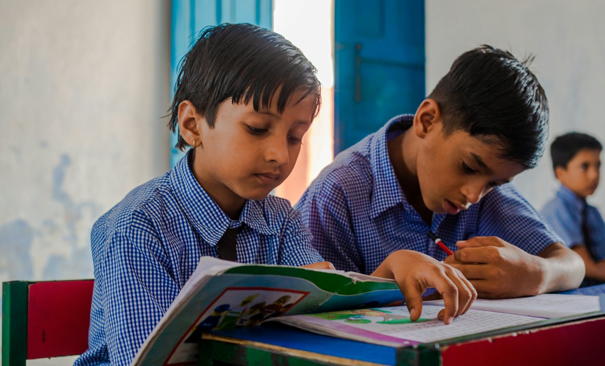 Two schoolboys solving problems together at a desk
